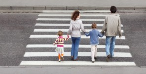 Eine vierköpfige Familie überquert einen Schutzweg